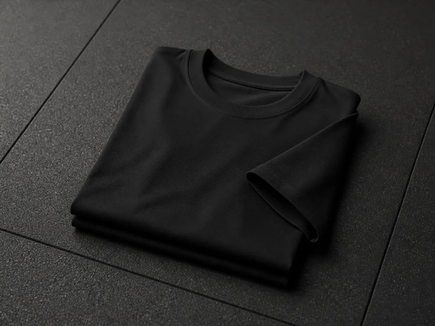 Illustrative product photograph of a folded unbranded black training shirt