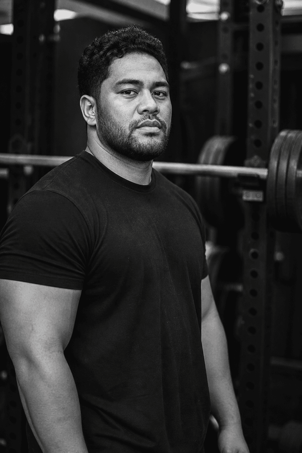 Person in a black shirt standing in front of a loaded barbell