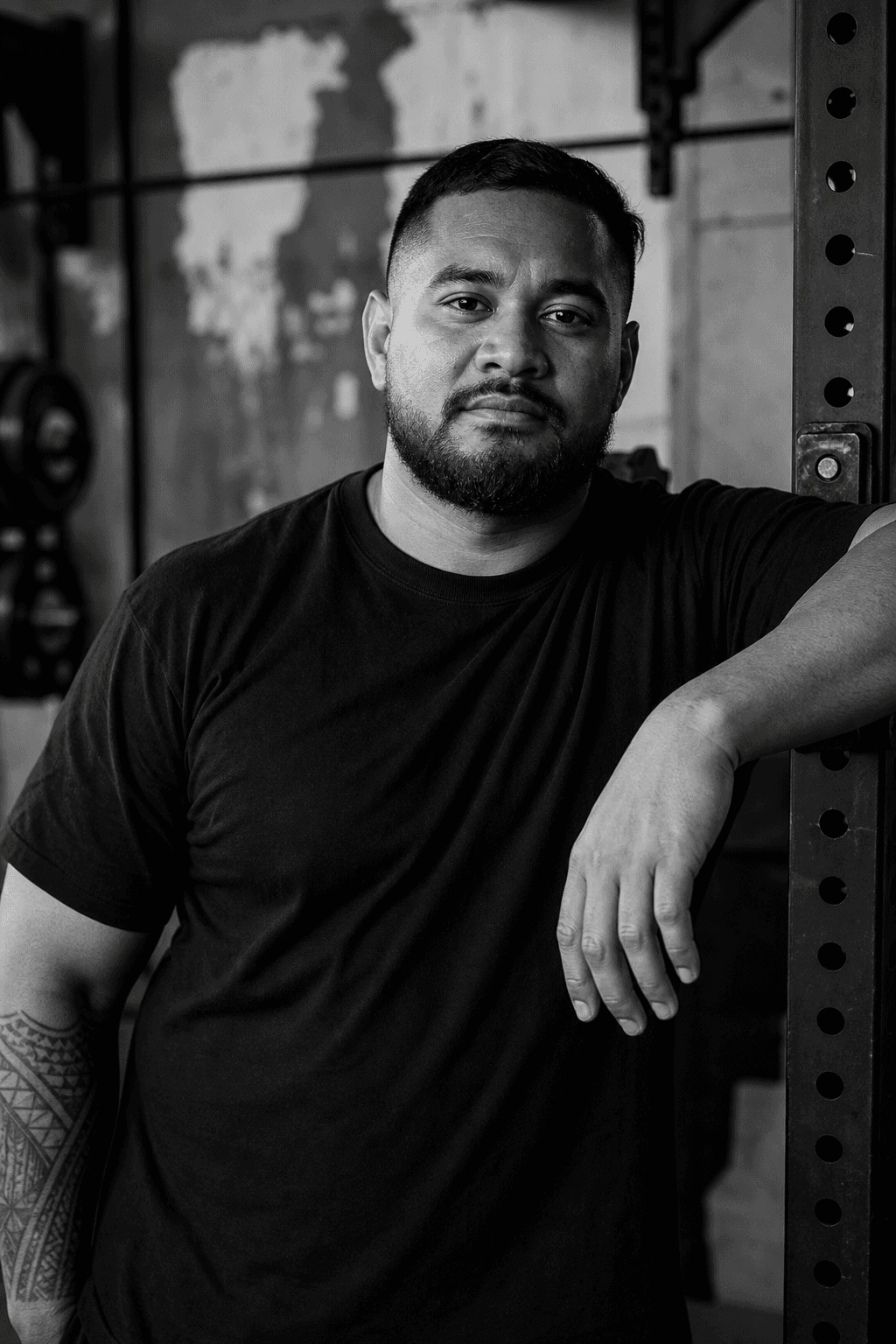 Person in a black shirt leaning on a power rack